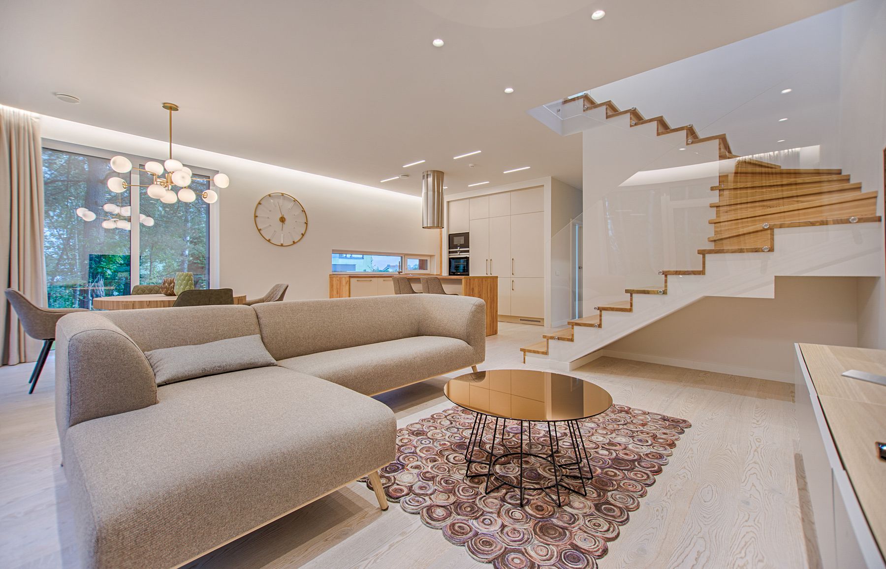 Bright living room with a neutral sofa and wooden staircase