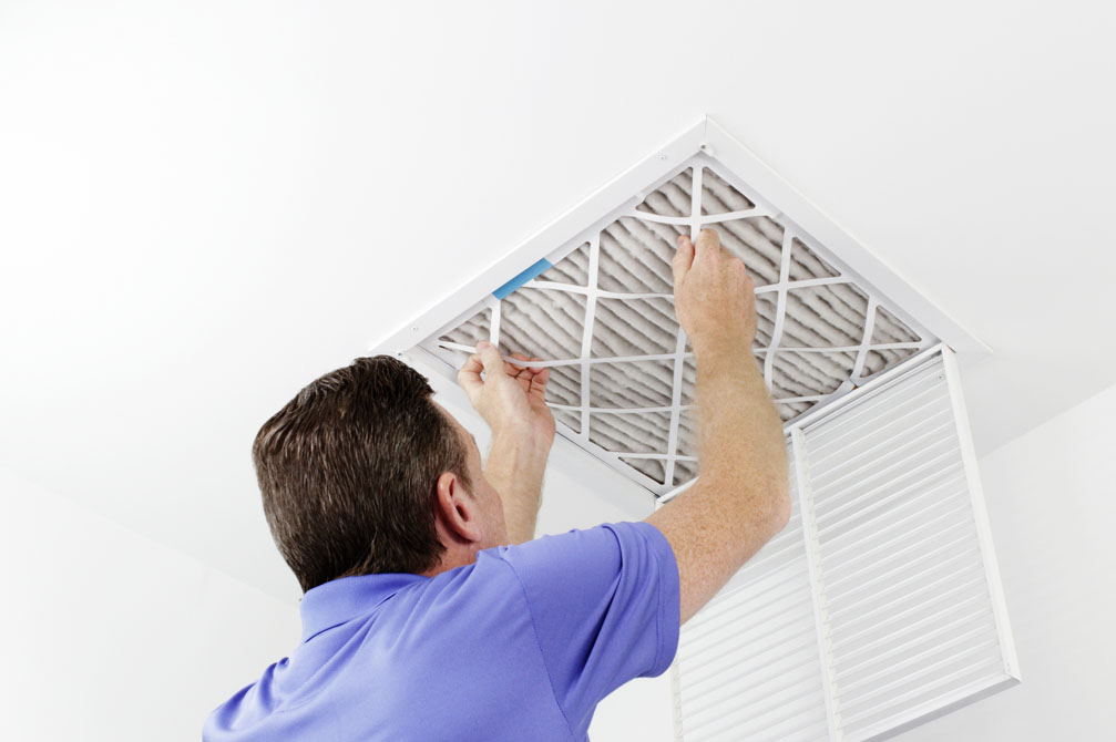 Technician replacing a/c filter